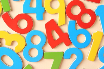 Colorful numbers on beige background, flat lay