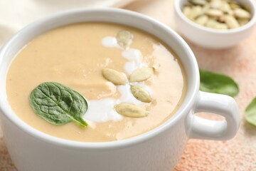 Healthy cream soup high in vegetable fats on color textured table, closeup