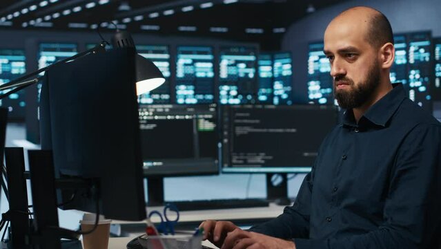 System administrator working in computer network security data center, ensuring optimal performance. Worker monitoring energy consumption across operational server racks components