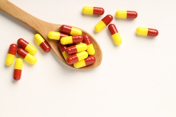 Antibiotic pills and spoon on white background, top view. Space for text