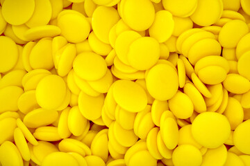 yellow chocolate coating in the form of callets, chocolate drops