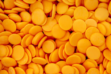 orange chocolate coating in the form of callets, chocolate drops