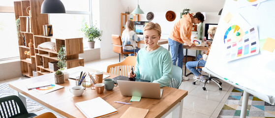 Female graphic designer working with tablet at table in office