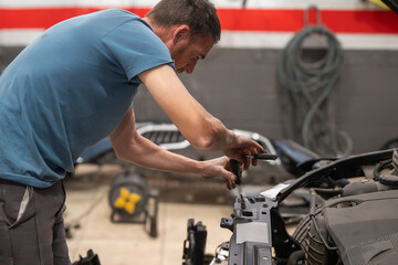 Mechanic Adjusting Car Engine Components in Workshop