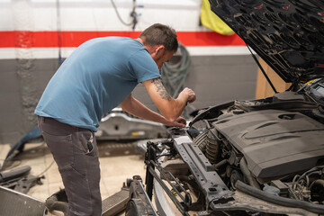 A man is working on a car engine