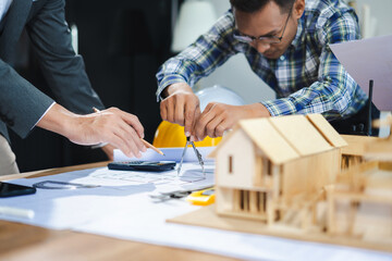 Working as a team architect and designer working on blueprint project of new apartments. Photo...