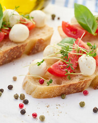 Round mozzarella, cherry tomatoes and microgreens on a piece of white bread, a healthy sandwich