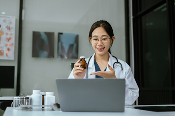 Caring asian therapist conducts video consultation, communicates with patient via an online conference, uses laptop, diagnoses, recommended and prescribed medications, and also answers questions.