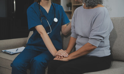 Female caregiver doing regular check-up of senior woman in her home.