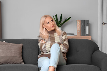 Obraz premium Displeased mature woman video chatting at home