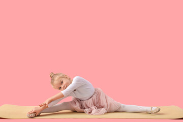 Cute little girl doing gymnastics on pink background