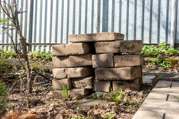 Stacked concrete slabs by a young sapling in early spring.