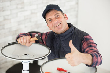 handsome man repairing chair at home