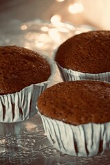 Freshly made homemade cupcakes up close with lights in the background.