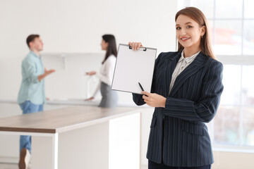 Female real estate agent with clipboard in kitchen