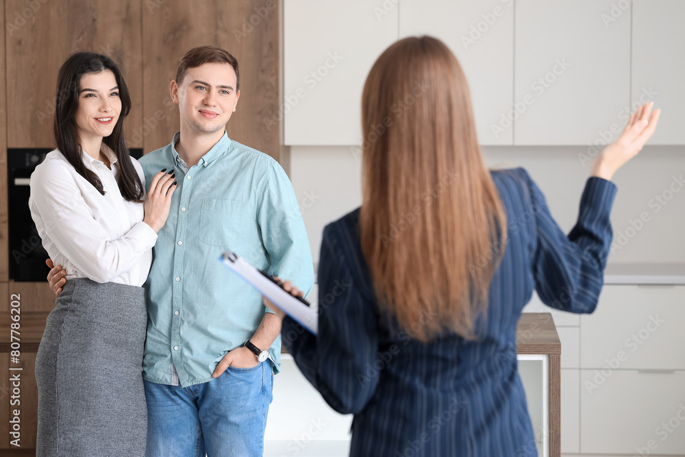 Sticker happy young couple with real estate agent in new house