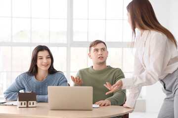 Real estate agent working with couple at table in office