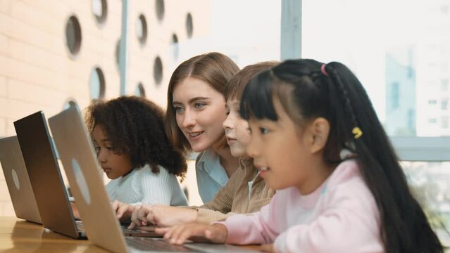 Smart teacher teaching and looking student using laptop at classroom. Professional instructor explained about programing engineering code or prompt while studying and learning program. Erudition.