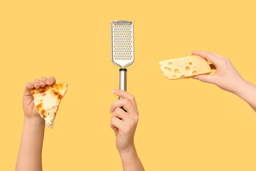 Many hands holding pizza slices, grater and cheese on yellow background