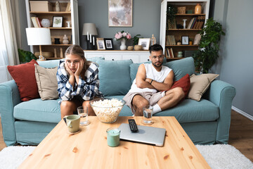 Communication problems, relationship difficulties. Young couple man and woman sitting on sofa at home, not talking after argue and misunderstanding. Two sad people having issue with ego and guilt. - obrazy, fototapety, plakaty