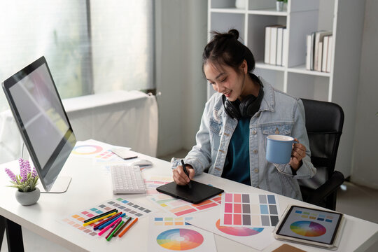 UX designer. Work on creative applications. Man with a palette in his hands. Designer applies the primary colors to the monitors. Development of a training application. Designer is a freelancer