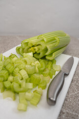 Diced green celery stalks on stone white board