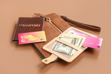 Composition with beige holder, credit cards, money, wallet and passport on brown background, closeup