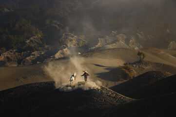 Silhouette of unidentified local people or Bromo Horseman at mountainside of Mount Bromo.