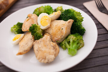 Healthy appetizer of chicken pieces with broccoli and quail eggs in bowl for healthy lunch