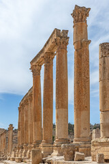 Ancient Roman ruins of columns with blue sky in the background at Jerash.  Jordan. Vertically. 