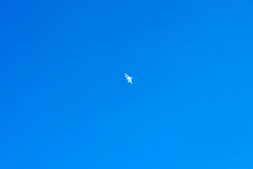 Supersonic fighter plane is flying on isolated blue sky