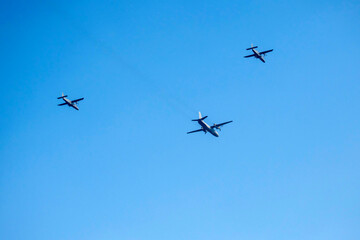Propeller airplane are flying as a v formation on isolated blue sky