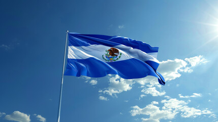 The national flag of El Salvador flutters against a blue sky with white clouds.