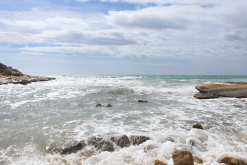 Fototapeta na wymiar natural background of sea sky and stones, beautiful view of Mediterranean coast in Spain, waves in the sea