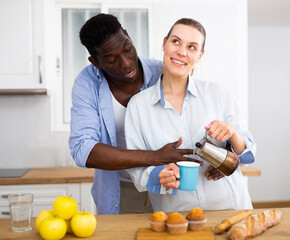 Happy couple preparing coffee and breakfast in kitchen - 807812423