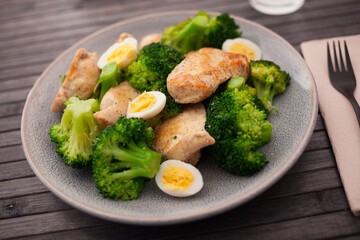 Chicken breast with broccoli and quail eggs on plate for healthy dinner