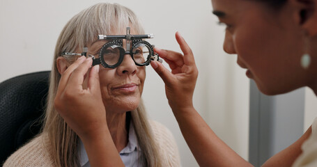 Women, optometrist and patient with trial lens for eye exam, vision test and prescription fro glasses at store. Doctor, consultation and equipment with assessment for eyesight, care and support © peopleimages.com