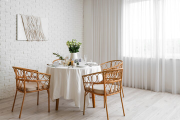 Beautiful table setting with eustoma flowers and candles for wedding celebration in room