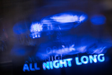 neon sign reading “ALL NIGHT LONG” in a blurry, enigmatic ambiance, clubbing
