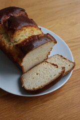 Homemade baked and sliced  Brioche Bread on a white plate on wooden table
