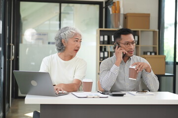 African Asian business man and woman successfully working and talking on the phone with customers