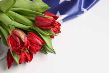 Obraz premium Beautiful tulip flowers and flag of USA on light background, closeup. Memorial Day celebration