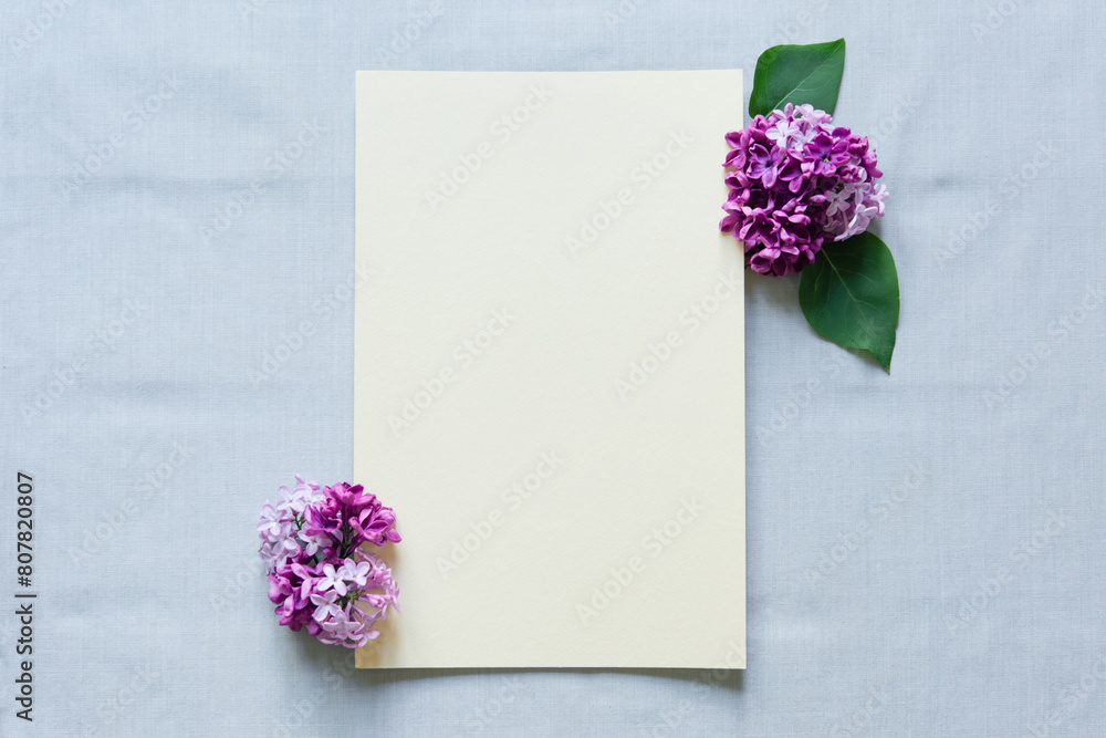 Sticker mockup blank paper sheet with lilac  flowers, top view, template empty card flat lay with copy space