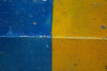 Horizontal photo. Yellow-blue texture background. Paint. Concrete stone wall of house painted in...