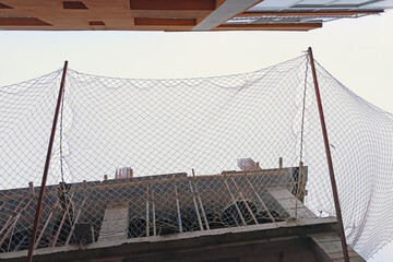 Protective mesh safety equipment at construction site. Falling debris protection