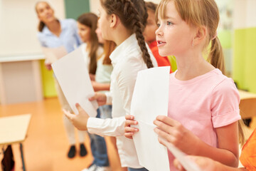 Girl singing during choir practice with classmates