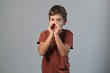 Young boy projects his voice, cupped hands around his mouth. This moment taps into the imaginative...