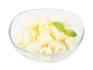 Tasty butter curls and basil leaves in bowl isolated on white