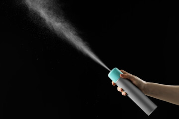 Woman spraying air freshener on black background, closeup. Space for text