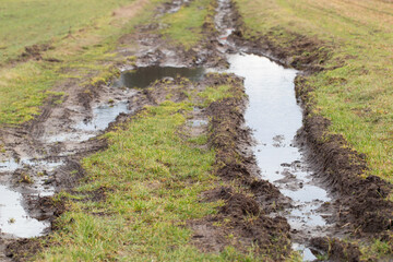Rural dirt road with puddles and mud, spring, thawing.